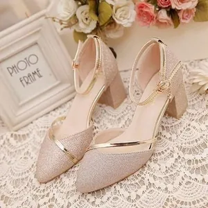 Primo piano di eleganti sandali glitter champagne con tacco largo e finiture dorate