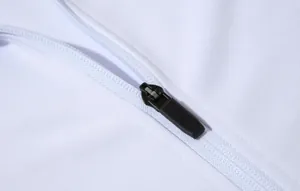 Gros plan détaillé d'une fermeture éclair noire sur une veste de sport blanche respirante