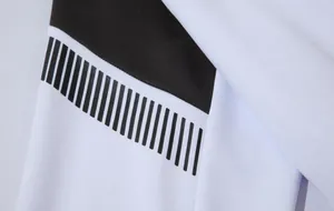 Détail rapproché des rayures verticales noires sur le tissu blanc d'une veste de sport