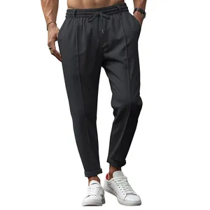 Detailed view of men's dark grey casual drawstring trousers with a stylish tapered leg fit