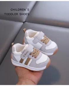 Close-up detail of grey and white toddler sneakers with soft soles and velcro strap