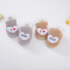 Detail von weichen Plüsch-Babystiefeln mit Herz-Patches und 'I love DAD' Stickerei