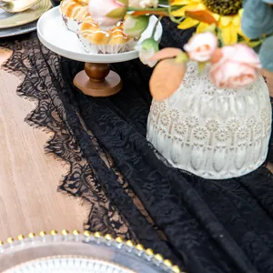 Detailed view of elegant black lace table runner with intricate floral patterns