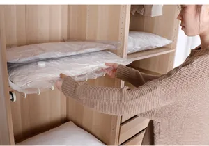 Detailansicht einer Person, die Steppdecken in Vakuumbeuteln im Schrank organisiert
