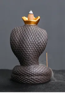 Macro detail of a cobra backflow incense burner with intricate scale texture and smoke