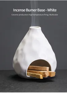 Primer plano de quemador de incienso de cerámica blanca con madera de Palo Santo y humo