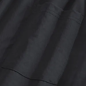 Detail shot of a rectangular patch pocket on black casual trousers showing fabric texture.