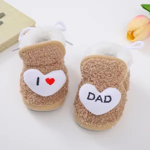 Nahaufnahme der kuscheligen braunen Plüsch-Babyschuhe mit Herz- und DAD-Stickerei