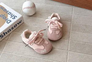Close-up detail of pink girls GAT sneakers featuring lace trim and embroidered bow accents