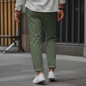 Detail view of olive green men's slim-fit business casual trousers on street