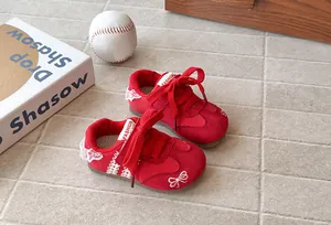 Elegant red sneakers for girls with delicate lace borders and embroidered bow details
