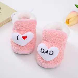 Detail von rosa Plüsch-Baby-Winterschuhen mit Herzstickerei „I Love Dad“.