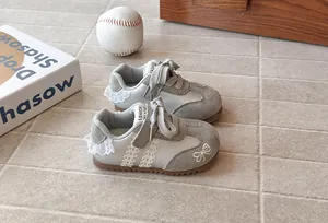 Detailed view of toddler girls' sneakers with lace trim and butterfly embroidery