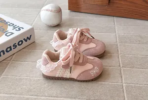 Close-up of pink girl's sneakers featuring delicate lace trim and sweet bow embroidery details