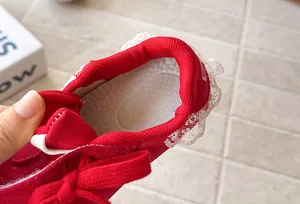 Detail of red children's German trainers with white lace trim and soft inner padding