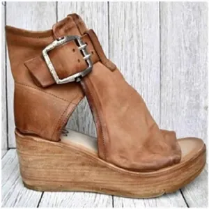 Seitenansicht einer braunen römischen Keilsandale aus Leder mit großer Schnalle und Peep-Toe.