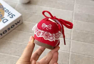 Close-up of red girls' trainer with delicate white lace and bow embroidery detail.