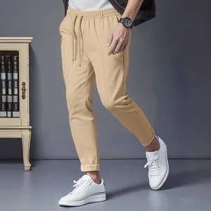 Detailed view of men's khaki drawstring casual pants with slim fit leg design