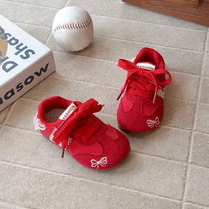Stylish red girls' training sneakers featuring bow embroidery and lace trim detail