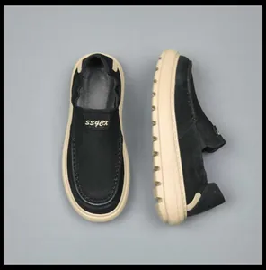 Detailed top and side view of black suede men's loafers with thick soft cream soles