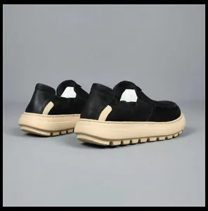 Rear view of stylish black men's slip-on loafers featuring a thick beige serrated sole