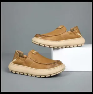 Detailed side view of tan leather loafers with thick serrated beige soles for men