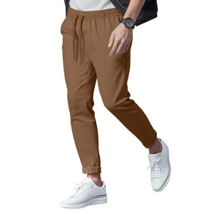 Close-up detail of brown drawstring pants for men featuring tapered leg and vertical seams