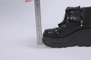 Nahaufnahme von schwarzem Punk-Plateaustiefel mit Lineal zur Anzeige der Sohlenhöhe