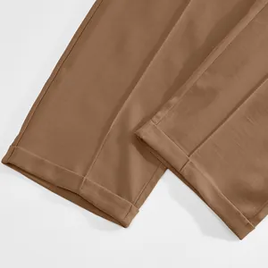 Close-up detail of brown men's casual trousers showing cuffed hem and fabric texture