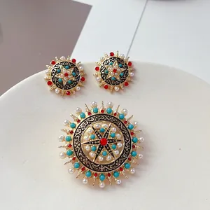 Vista dettagliata di un set di gioielli boho vintage in oro con perle e dettagli in turchese