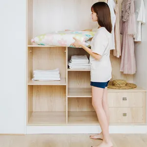 Floral vacuum compression storage bags for clothing being organized in a wooden wardrobe
