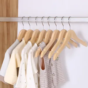 Premium set of 10 smooth wooden clothes hangers for infants and children on closet rod.