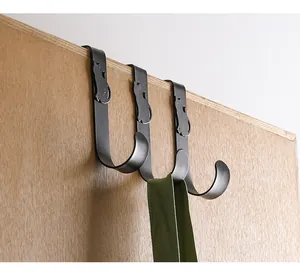 Close-up of black cat-shaped over-door S-hooks on a wooden cabinet edge