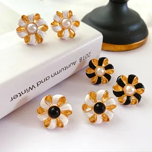 Gros plan détaillé de boucles d'oreilles fleurs en émail baroque vintage avec perles