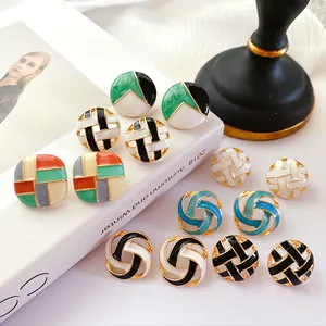 Macro view of vintage enamel stud earrings in various colorful geometric patterns and designs.