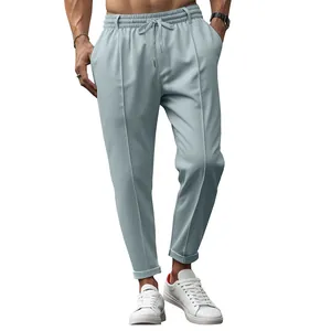 Detail of light blue men's drawstring casual trousers with tapered hem