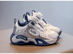 Side view of white and navy kids sports shoes featuring a rotary dial lacing system