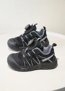 Detailansicht von atmungsaktiven schwarzen Kindersportschuhen mit einem Drehverschluss.