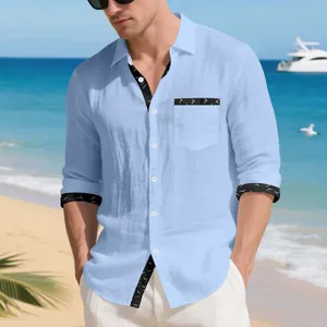 Detail view of men's light blue long-sleeve linen shirt with bird print trim on beach
