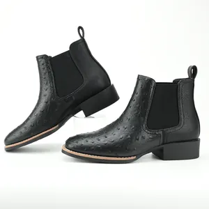 Close-up of the embossed ostrich texture on black Chelsea boots with a sturdy block heel