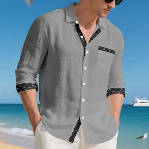 Detail view of grey linen long-sleeved men's shirt with bird pattern trim on pocket.