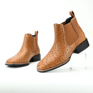 Close-up of brown ostrich pattern Chelsea boots with elastic side panels and block heels.