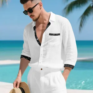 Detailed view of men's white linen resort shirt featuring black bird-patterned trim on cuffs