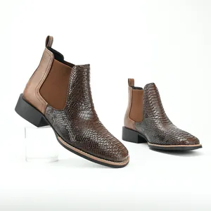 Macro view of brown ostrich-texture Chelsea boots featuring a classic retro chunky heel.