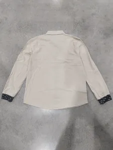 Back view of men's loose linen long sleeve shirt featuring printed cuffs in beige tone