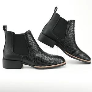 Detailed side view of black men's Chelsea boots with ostrich texture and block heel