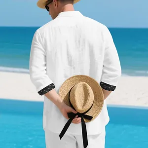 Back view of a white linen casual shirt with patterned cuffs in a beach setting