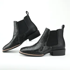 Close-up of black ostrich pattern Chelsea boots with chunky heels and retro style