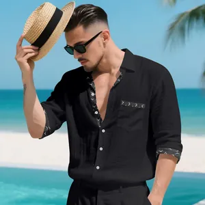 Detailed view of a black linen shirt featuring patterned trim on cuffs and pocket.