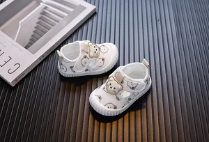 Detalle de zapatos para caminar transpirables para bebé en blanco con motivos de oso